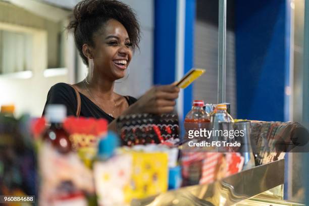 jeune brésilienne acheter certains produits rues - marché de plein air photos et images de collection