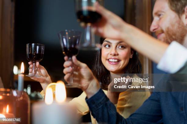 happy friends toasting wineglasses at home - wine christmas stock pictures, royalty-free photos & images