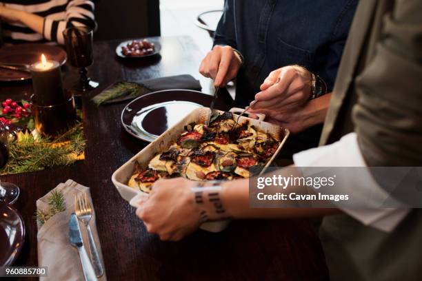 cropped image of woman serving food to friends at table during christmas - portion control stock pictures, royalty-free photos & images