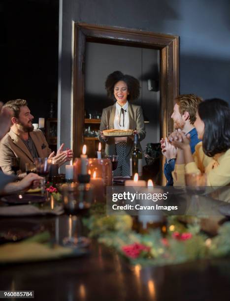 friends enjoying meal during christmas at home - table dinner winter imagens e fotografias de stock