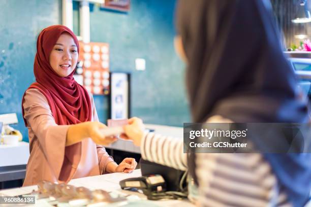 shop keeper accepting the cash from the customer - veil stock pictures, royalty-free photos & images