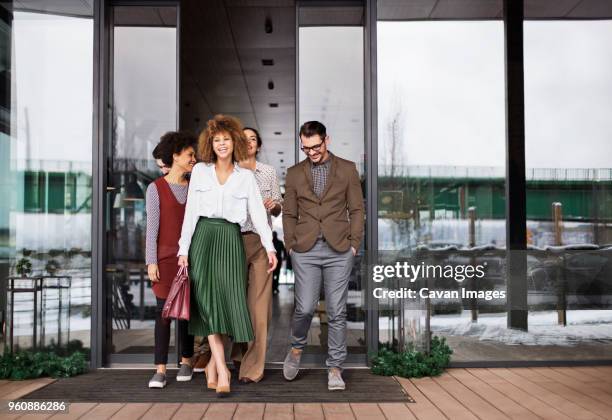 happy business people leaving cafe - four people walking away stock pictures, royalty-free photos & images