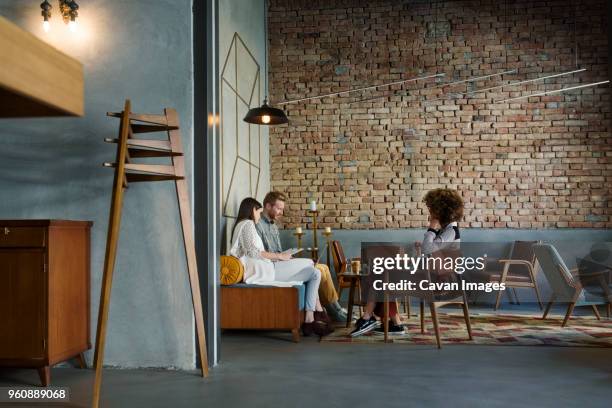 creative business people discussing in hotel lobby - brick wall business person stock pictures, royalty-free photos & images