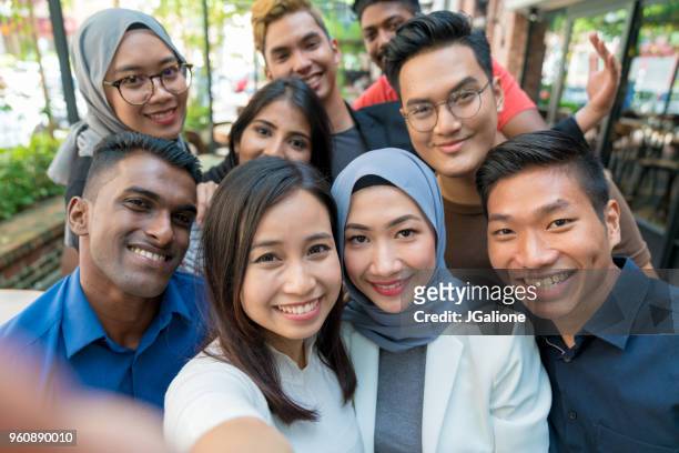 gruppe von freunden, die ein selfie  - malaysian culture stock-fotos und bilder