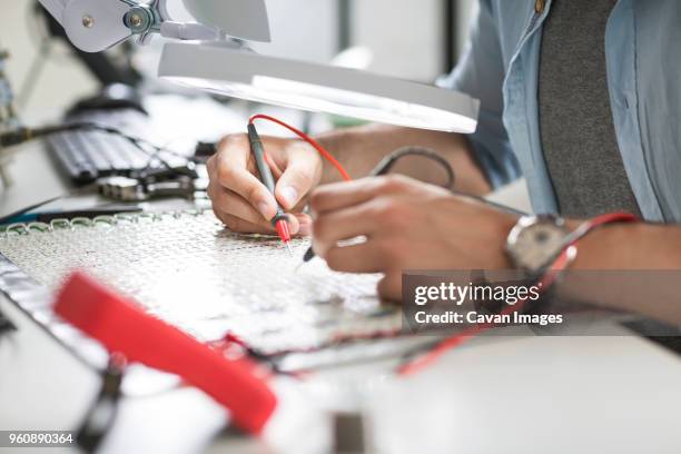 close-up of engineer soldering circuit at table in electronics industry - last day stockfoto's en -beelden