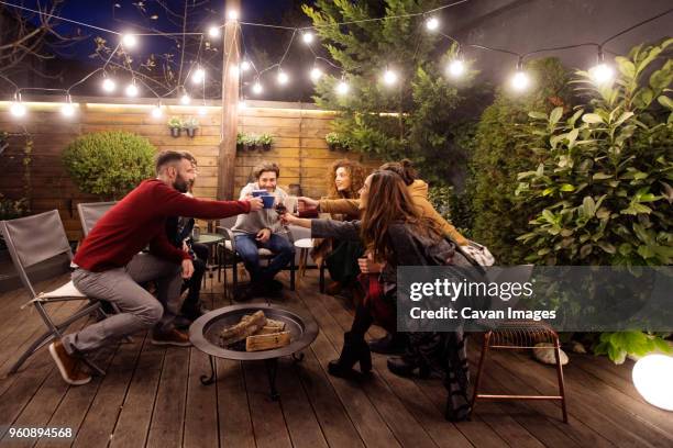 happy friends toasting drinks in party at night - fire pit stock pictures, royalty-free photos & images