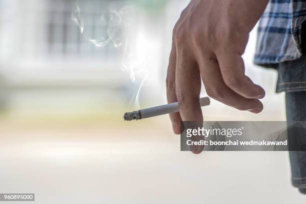 man smoking a cigarette - smoking cigarette photos et images de collection