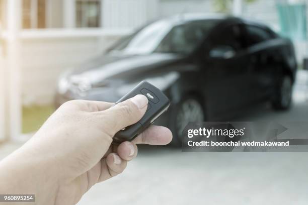 men's hand presses on the remote control car alarm systems. - car isolated doors open stock pictures, royalty-free photos & images