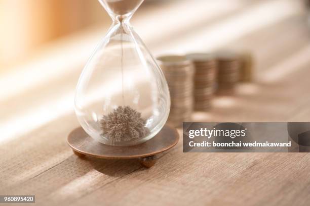 deadline and time is money concept with hourglass - deadline stockfoto's en -beelden