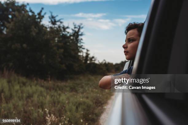 thoughtful teenage boy looking through window in car - teenage boy looking out window stock pictures, royalty-free photos & images