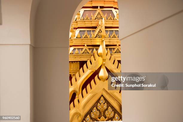 gold roof of loha prasat is seen through a vault - sunphol foto e immagini stock