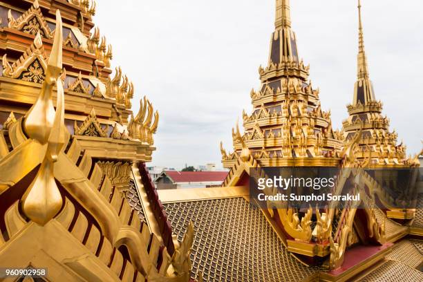 decorated gold spires and roof of loha prasat - sunphol stockfoto's en -beelden