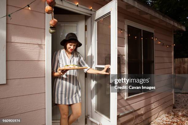 party hostess bringing food on cutting board while exiting house - fish in bulb stock pictures, royalty-free photos & images