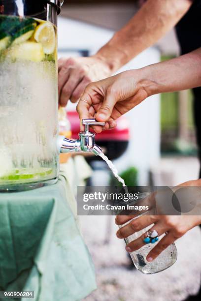 cropped image of woman filling lime juice in glass jar - lime juice stock pictures, royalty-free photos & images