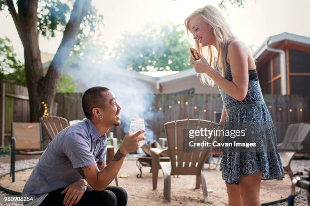 happy friends having drink and hot dog at yard - asian eating hotdog stockfoto's en -beelden