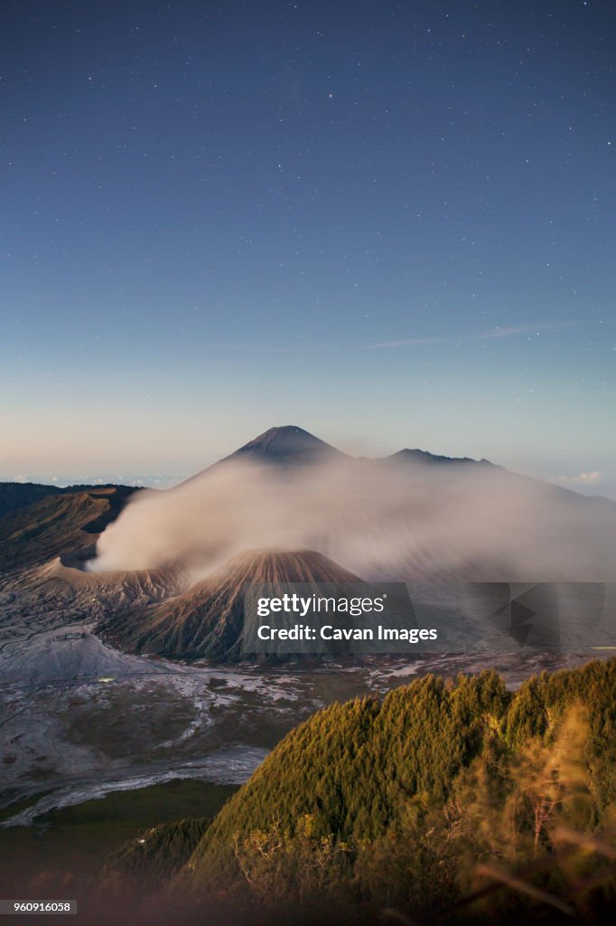 Scenic view of landscape against blue sky at Mount Bromo