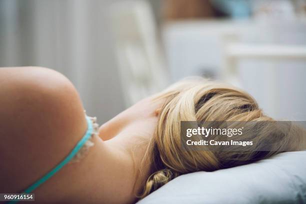 rear view of woman sleeping on bed - woman back pillow blonde stock pictures, royalty-free photos & images