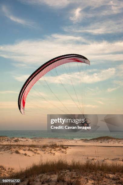 man paragliding over sea against sky - pensacola beach stock-fotos und bilder