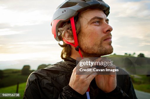 Thoughtful man wearing helmet against sky Thoughtful man wearing helmet against sky