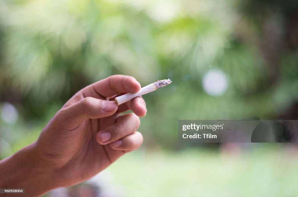 Man smoking cigarette, Hand on young man smoking cigarette