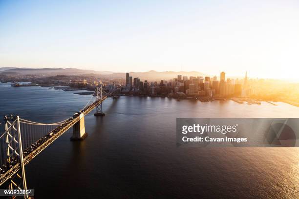 aerial view of bay bridge and cityscape against clear sky - baía de são francisco imagens e fotografias de stock