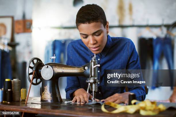 female fashion designer using sewing machine in workshop - frau nähen stock-fotos und bilder