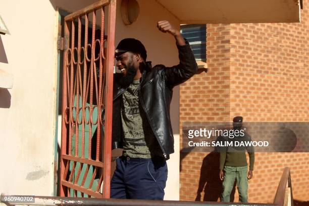 Zambian musician Chama Fumba, known as as Pilato , gestures as he arrives at the Lusaka Magistrate Court on May 21, 2018. - A Zambian court on May 21...