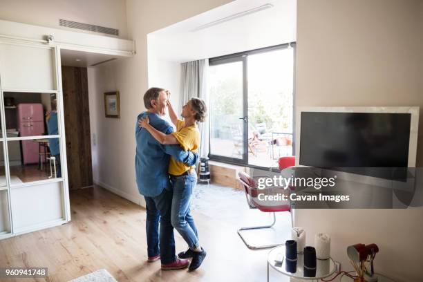 side view of senior couple dancing at home - couple dancing at home stockfoto's en -beelden