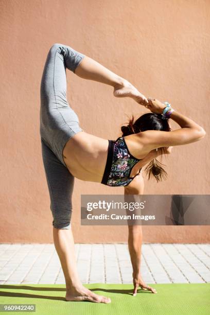 young woman doing yoga on sidewalk - legs up wall yoga stock pictures, royalty-free photos & images
