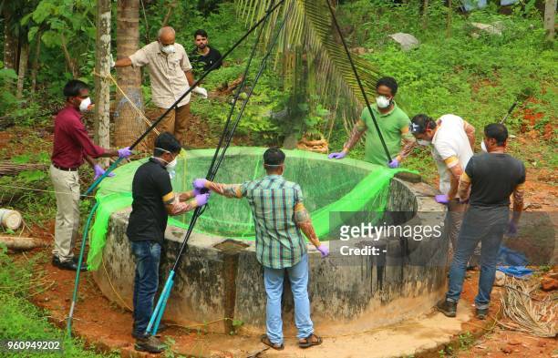 Animal Husbandry department and Forest officials inspect a well to to catch bats at Changaroth in Kozhikode in the Indian state of Kerala on May 21,...