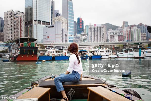side view of female tourist looking at buildings by sitting on boat - china tourism stock pictures, royalty-free photos & images