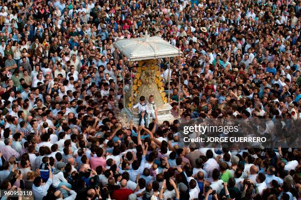 Pilgrims gather around a statue of the Virgin Mary being paraded during a procession in the village of El Rocio, southern Spain, on May 21, 2018. -...