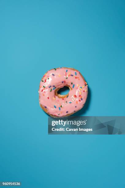 overhead view of doughnut on blue background - donuts fotografías e imágenes de stock