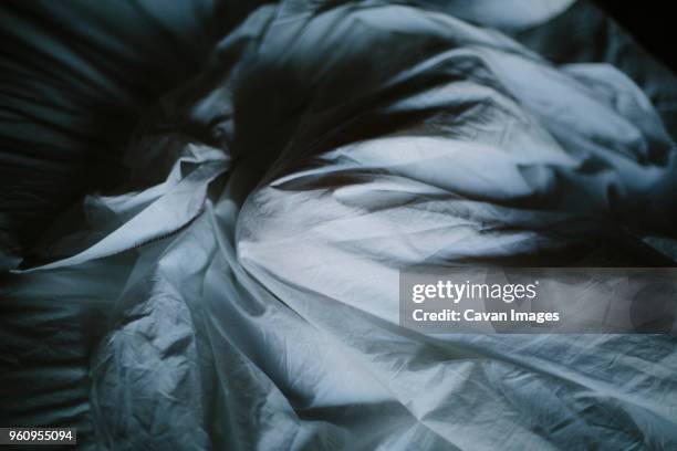 overhead view of crumpled bed sheet - crumpled stock-fotos und bilder