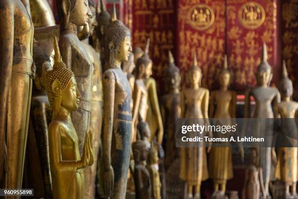 buddha statues at the wat xieng thong temple in luang prabang - laotian culture stock pictures, royalty-free photos & images