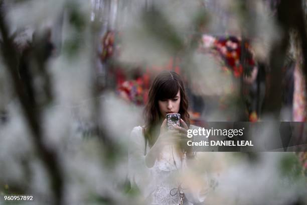 Visitor uses a smartphone to take a photograph of a floral display during a visit the 2018 Chelsea Flower Show in London on May 21, 2018. - The...