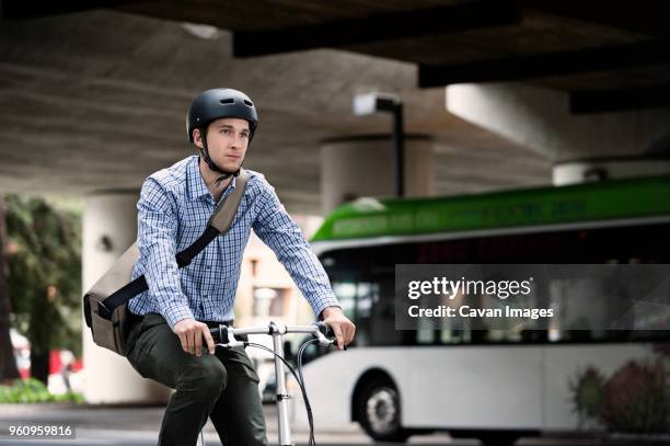 businessman riding bicycle on city street - man riding bus stock pictures, royalty-free photos & images