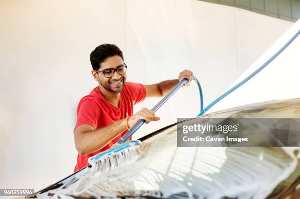 man washing car with broom in garage - indian ethnicity man car stock pictures, royalty-free photos & images