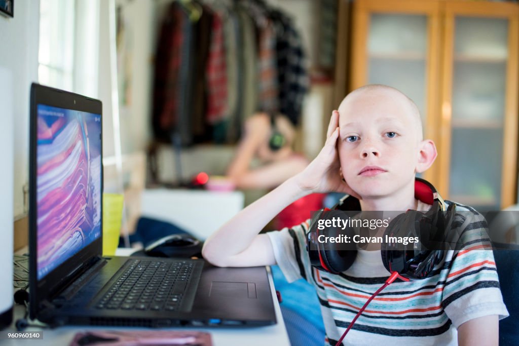 Portrait of serious boy with headphones at home