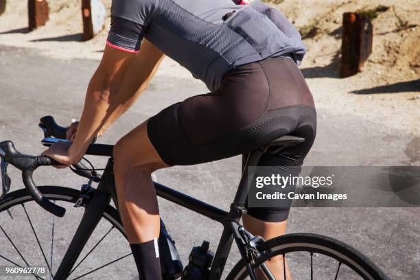 midsection of man cycling on road - shorts stock pictures, royalty-free photos & images