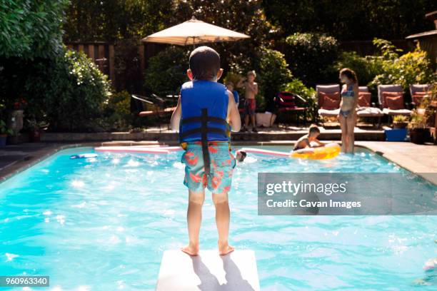 boy standing on diving board - life jacket stock pictures, royalty-free photos & images