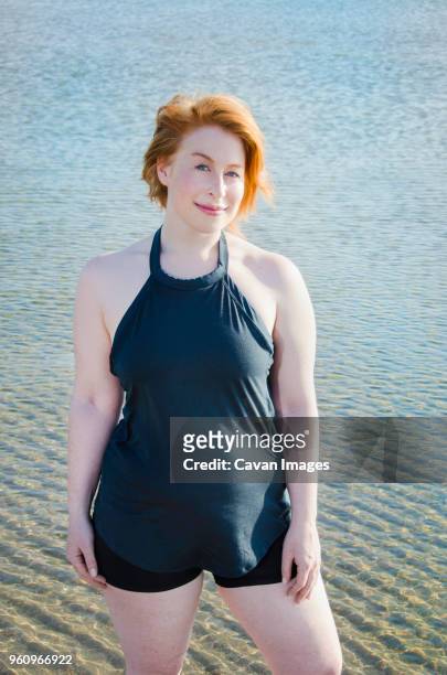 high angle portrait of confident woman standing on shore - fat redhead stock pictures, royalty-free photos & images