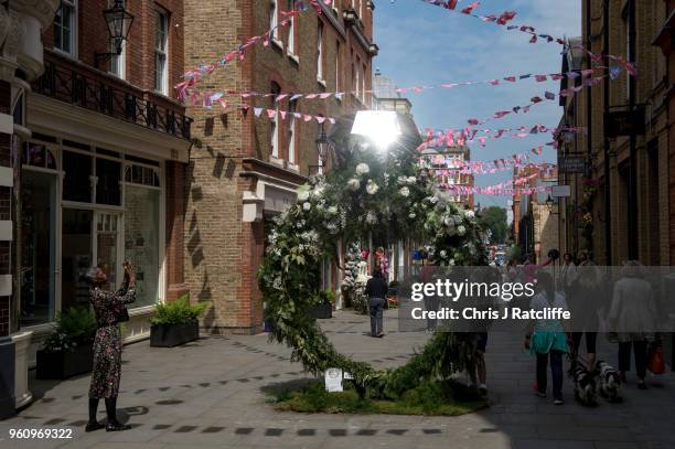 Woman takes a photo of a floral display shaped like a diamond ring during the Chelsea in Bloom floral art show on May 21, 2018 in London, England....