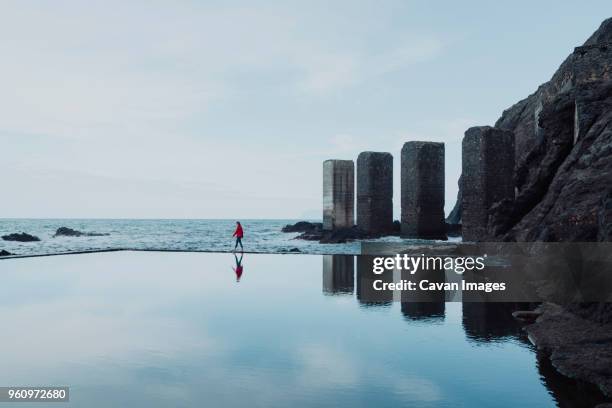 side view of woman walking by swimming pool against sea and sky - gomera bildbanksfoton och bilder