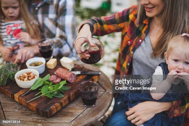 family having food at table in backyard - mint plant family fotografías e imágenes de stock