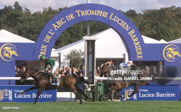 Irish jockey Johnny Murtagh ridding Sinndar crosses the finish line ahead of Olivier Doleuze on Egyptband during the Group One Prix de l'Arc de...