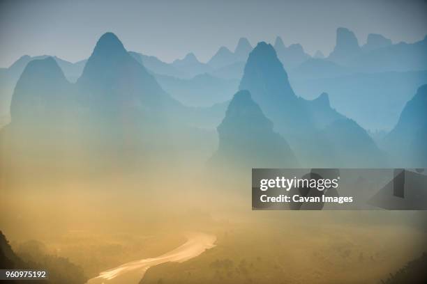 scenic view of mountain against dramatic sky during foggy weather - xingping stock pictures, royalty-free photos & images