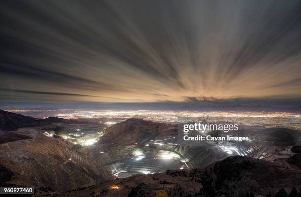 high angle view of bingham canyon and illuminated cityscape against cloudy sky - bingham canyon mine stock pictures, royalty-free photos & images