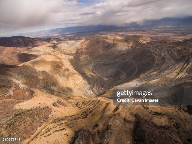 high angle view of bingham canyon against cloudy sky - bingham canyon mine stock pictures, royalty-free photos & images