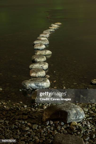 row of rocks in river at riverbank - xingping stock pictures, royalty-free photos & images